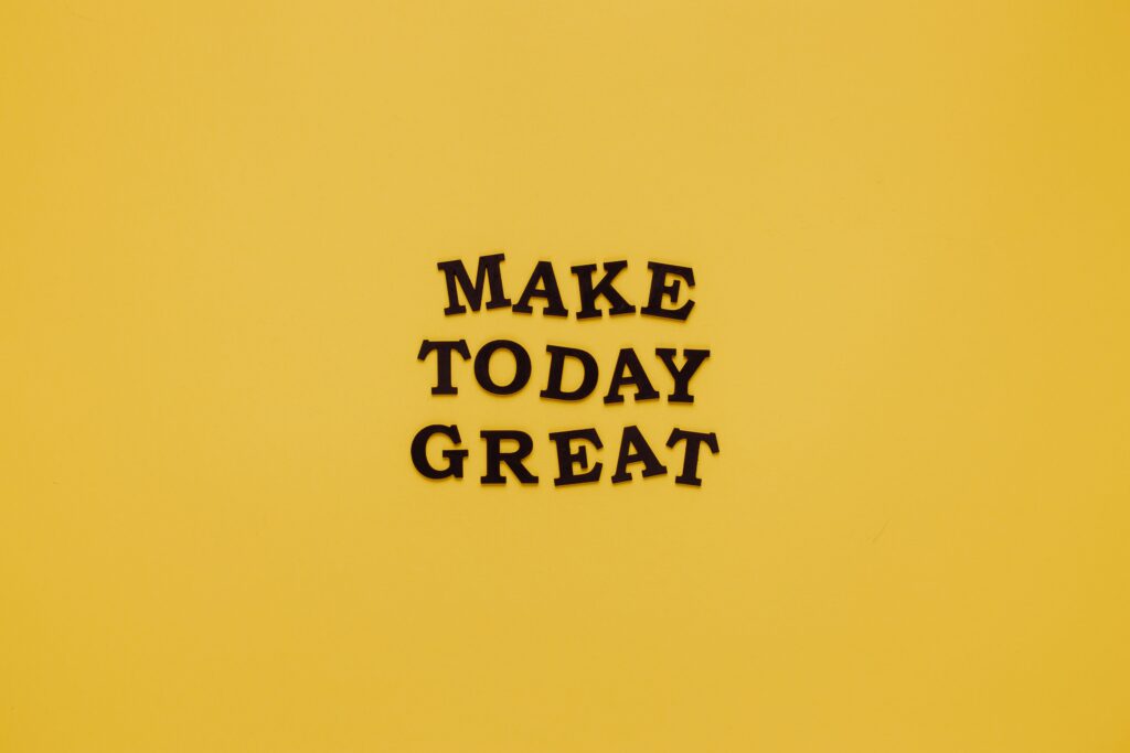 Simple and motivational quote 'Make Today Great' on a minimalist yellow background for inspiration.